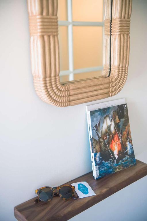 a shelf with a picture and sunglasses on it at The Surfjack Hotel & Swim Club in Honolulu