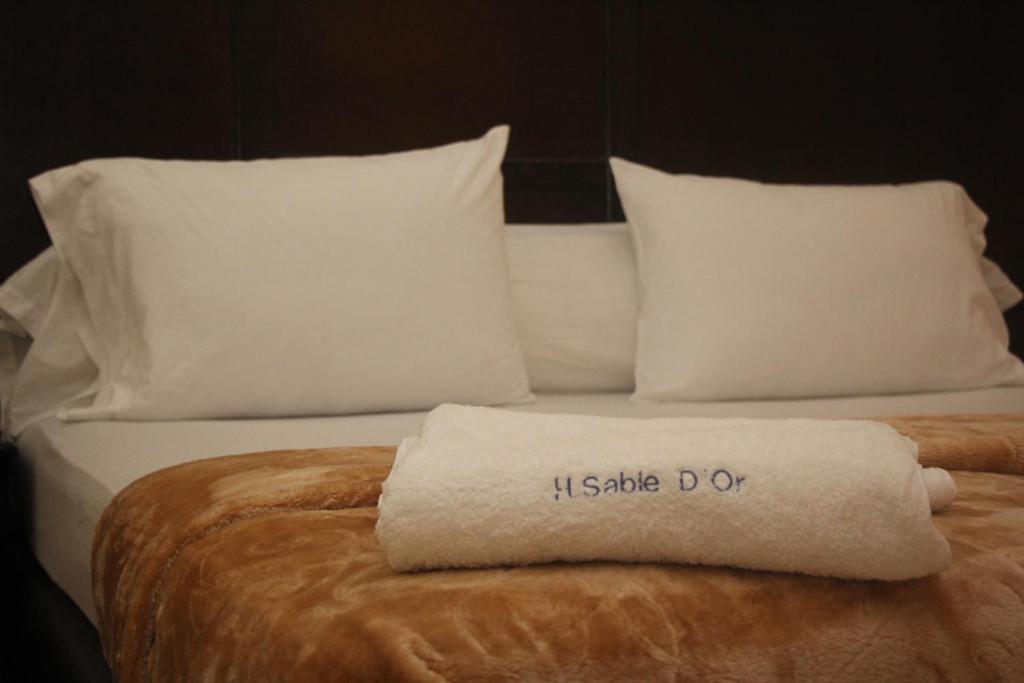 Una cama o camas en una habitación de Hôtel Sable d'Or