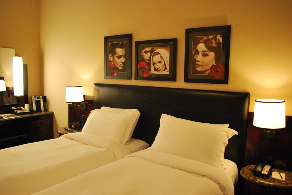 two beds in a hotel room with pictures on the wall at Washington Square Hotel in New York