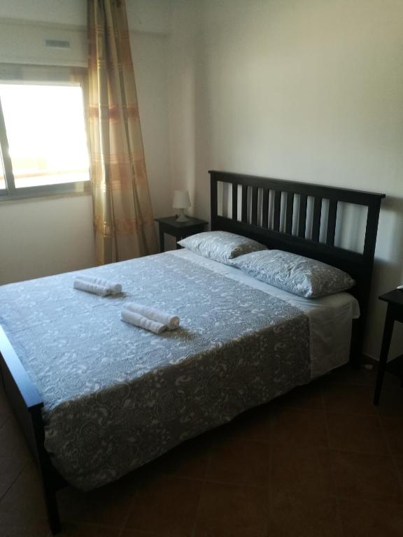 a bedroom with a bed with two bottles on it at Casavacanze corallo in Isola delle Femmine