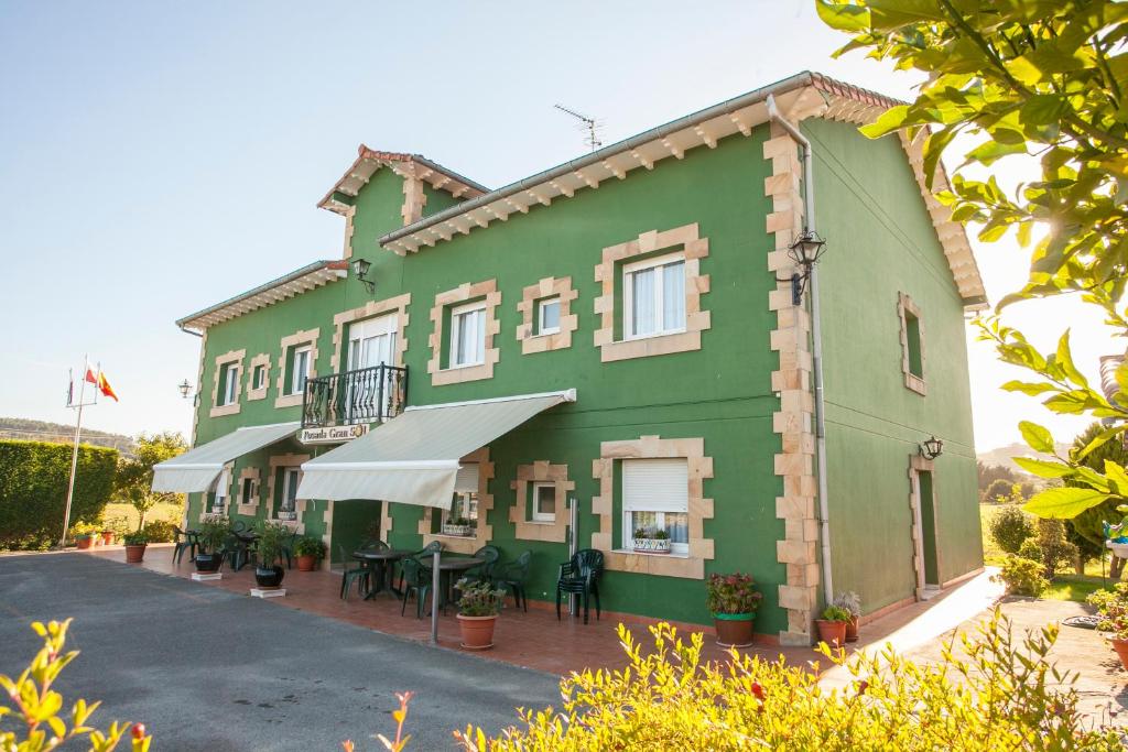 克維達的住宿－波薩達格蘭蘇爾酒店，一座绿色建筑,前面设有一张桌子