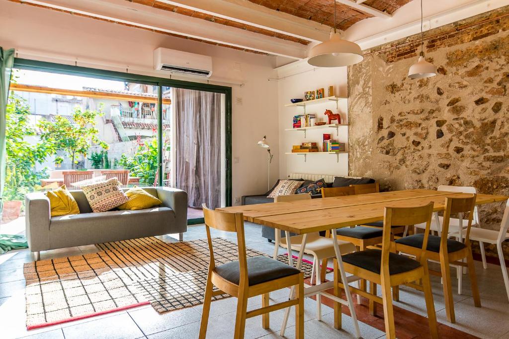 uma sala de estar com uma mesa de madeira e cadeiras em Casa Creu em Sant Feliu de Guíxols