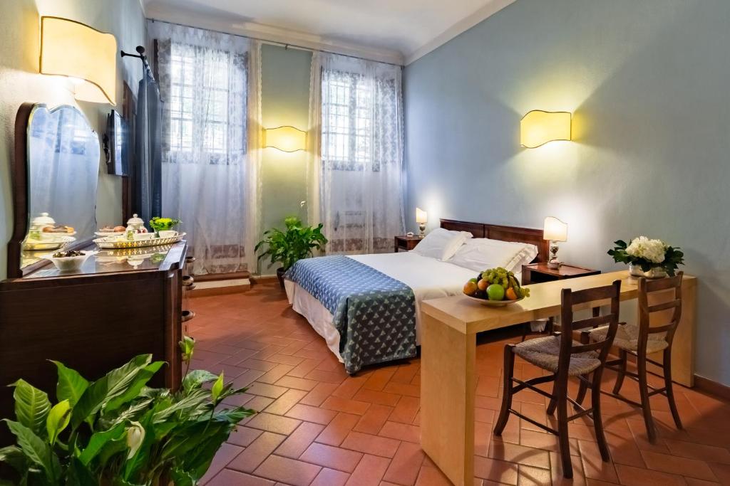 een hotelkamer met een bed en een tafel en stoelen bij Oltrarno 9 in Florence