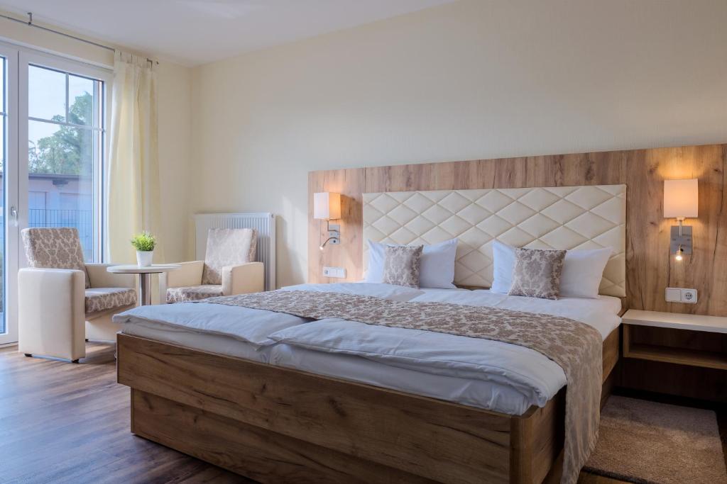 una camera da letto con un letto grande con testiera in legno di Restaurant & Hotel Storchenklause a Storkow