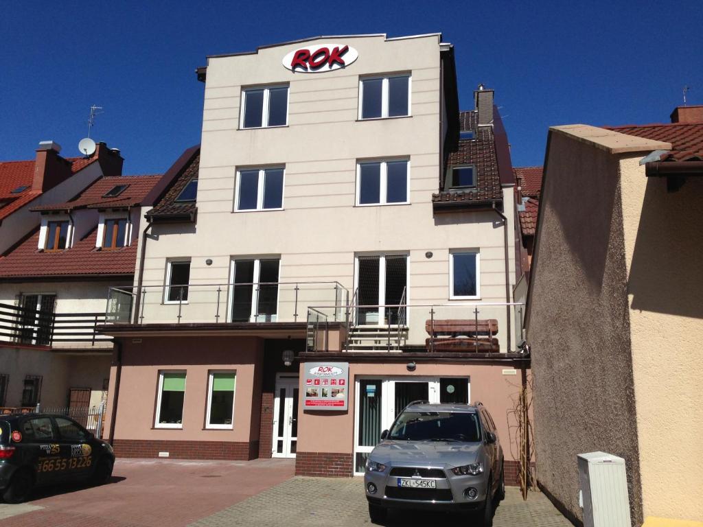 a kx building with a car parked in front of it at Apartamenty Rok in Kołobrzeg