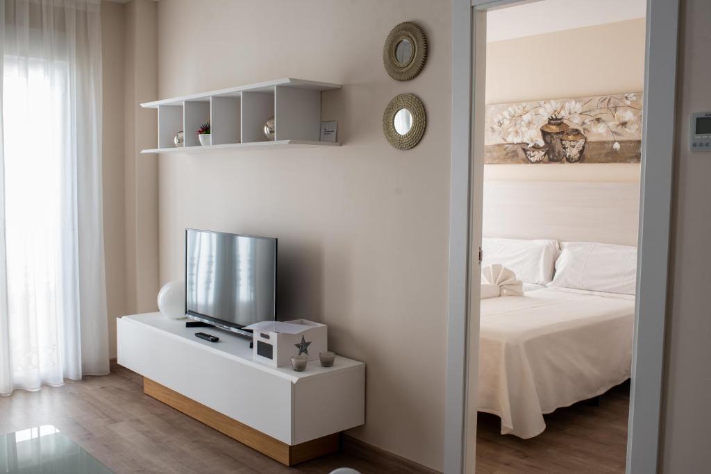 1 dormitorio con 1 cama y TV en una mesa en Apartamentos Massò, en Albacete