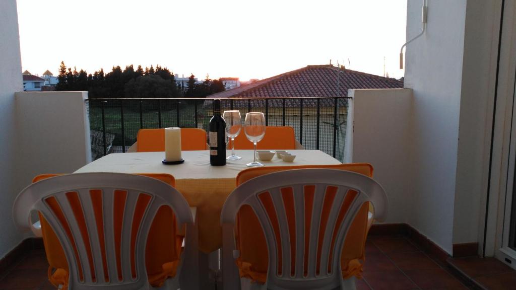 コニル・デ・ラ・フロンテーラにあるVerdeMar-Terraza-Sólo familiasのテーブル(椅子2脚付)とワイン1本