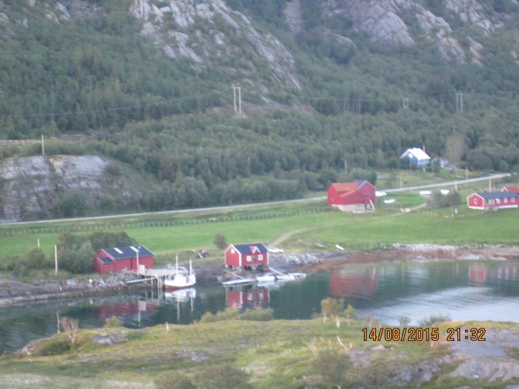 a group of houses and boats in a body of water at Esjeholmen Feriehus in Jektvik