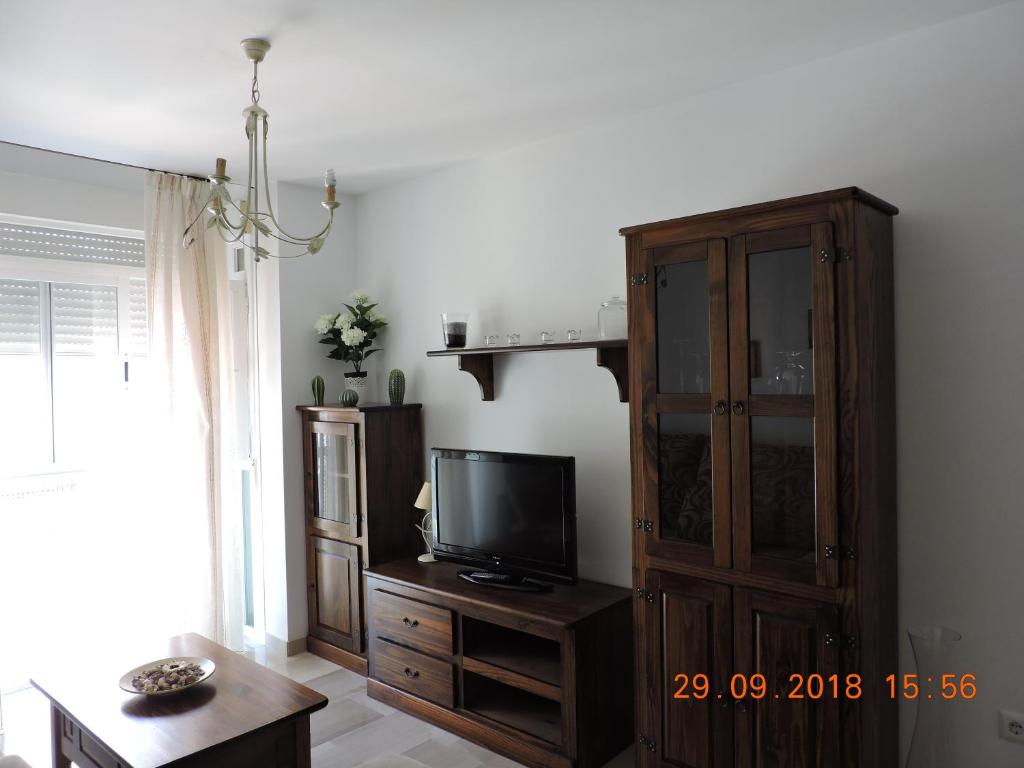 ein Wohnzimmer mit einem TV und einem Holzschrank in der Unterkunft 29 Calle Cártama in La Cala de Mijas