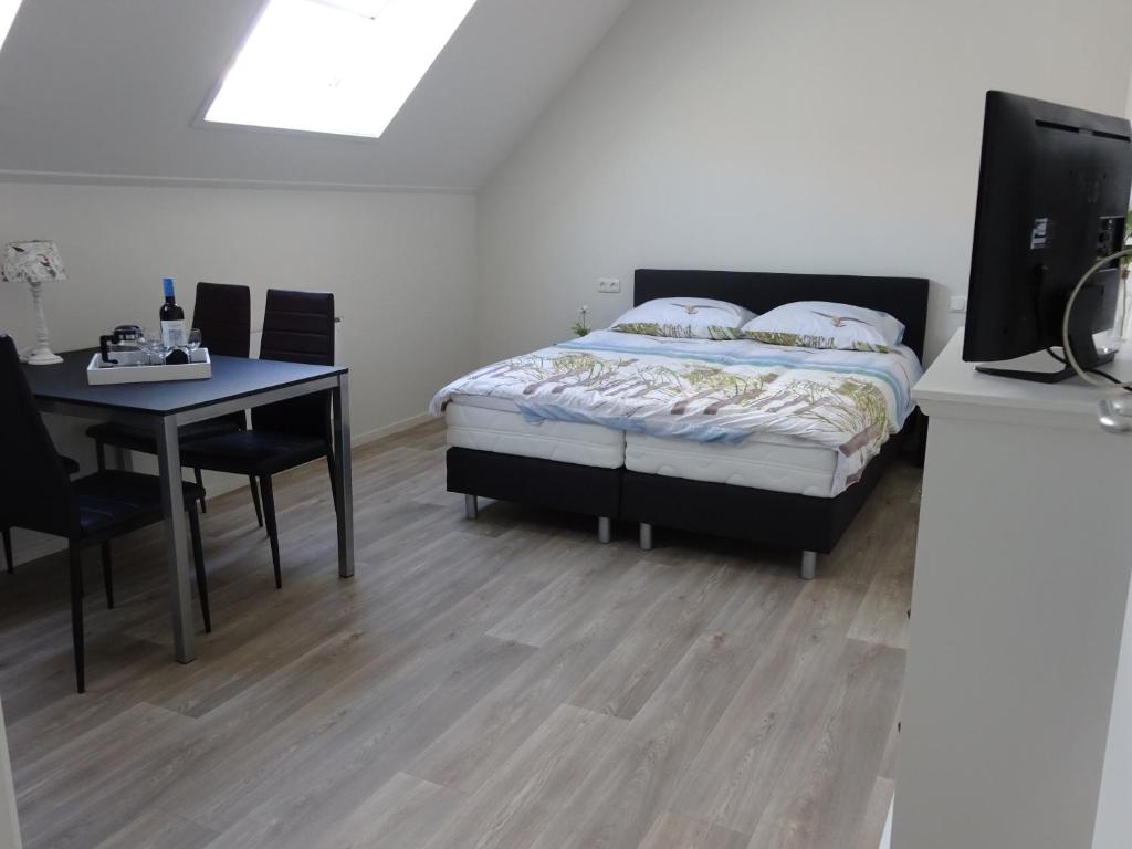 1 dormitorio con 1 cama y escritorio con ordenador en Het Bakkersschuurtje, en Colijnsplaat