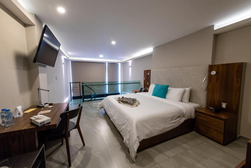 Dormitorio con cama, escritorio y TV en JTowers, en Ciudad de México