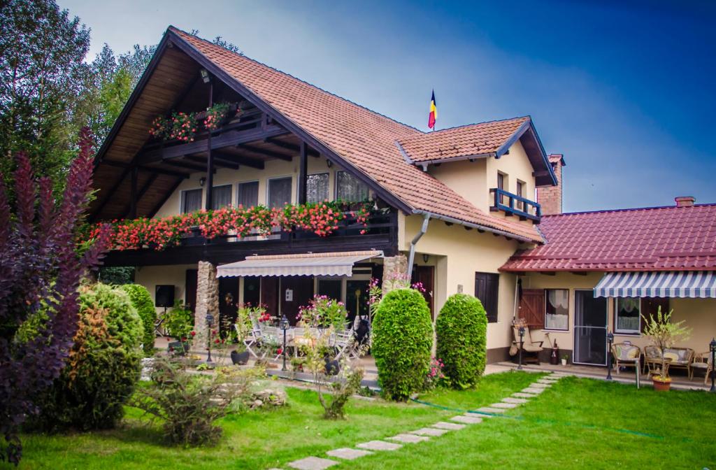 una casa con un jardín delante de ella en Casa Csiki, en Râșnov