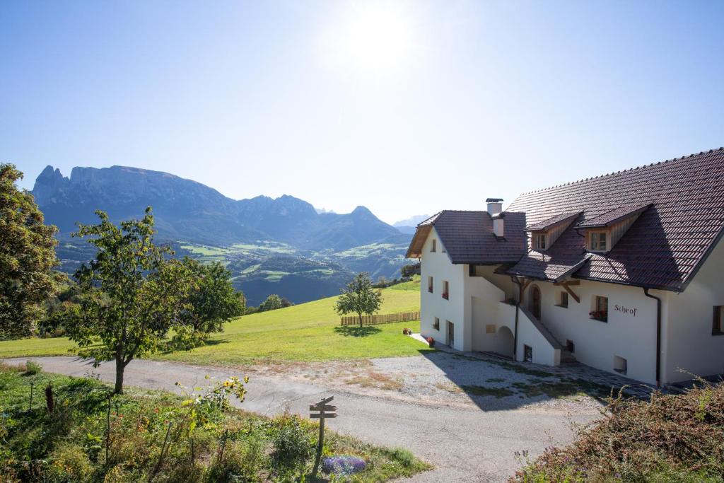 a white house with mountains in the background at Brunnerhof-Schrof in Collalbo