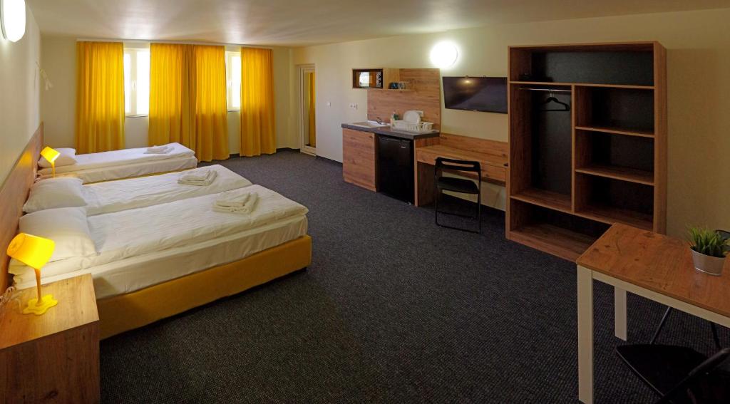 a hotel room with a large bed and a desk at Стаи за Гости "ЦЕНТРАЛ" Фамилни Стаи & Апартаменти in Gabrovo