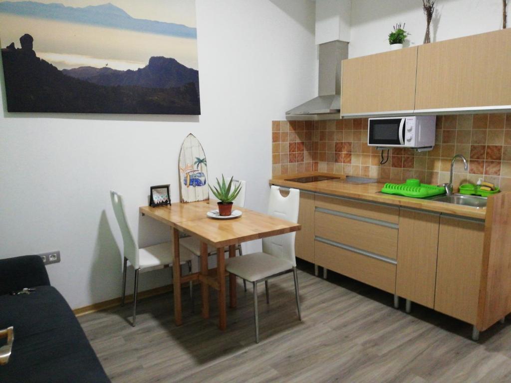 una pequeña cocina con mesa de madera, mesa y sillas en Apartamento la piedra viva 3 arinaga, en Arinaga