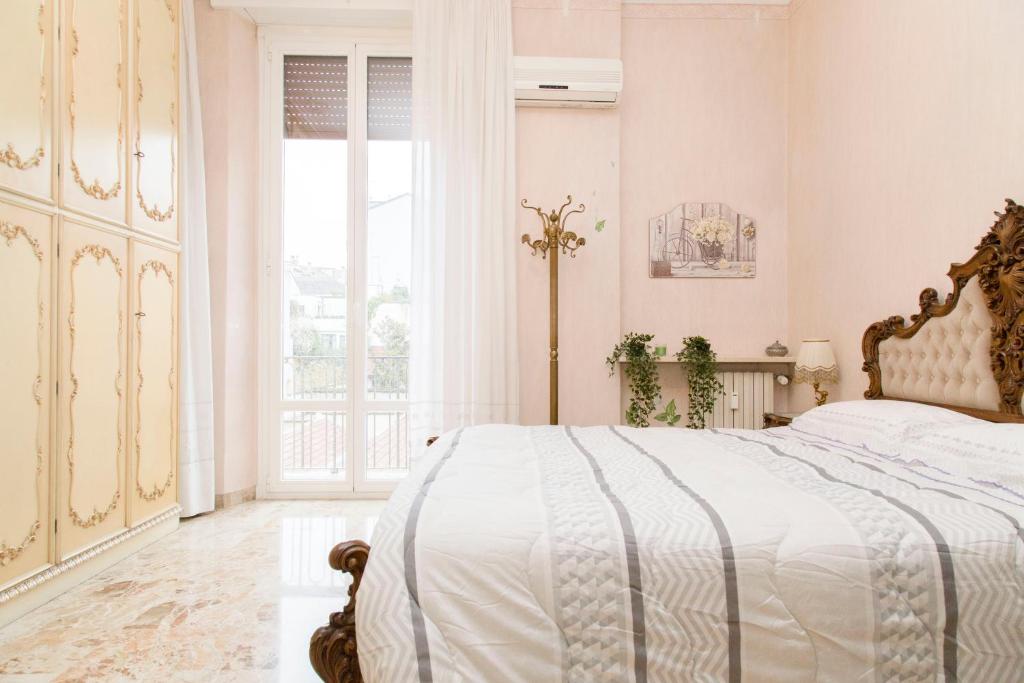 Habitación blanca con cama y ventana en Elegant and cozy apt in Città Studi, en Milán