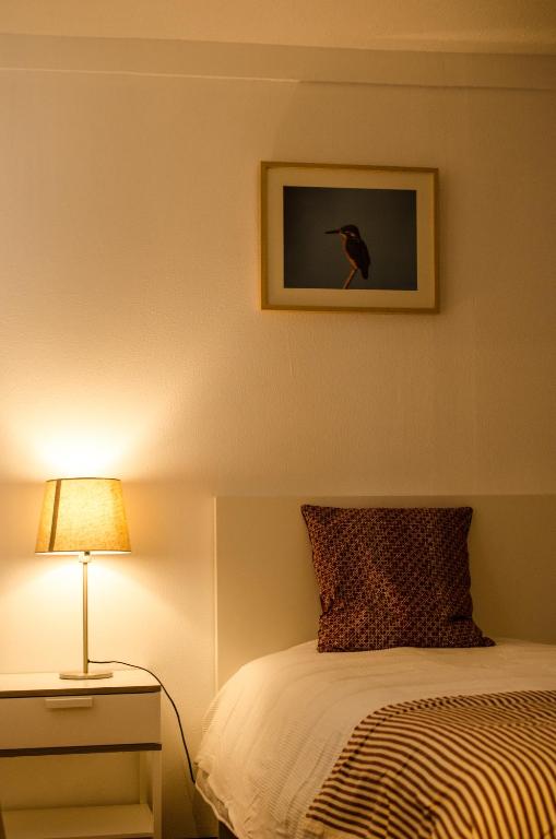 a bedroom with a bed and a lamp and a picture at Casa da Avó Tina in Castelo de Vide