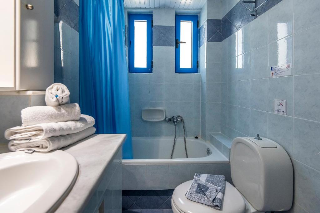 a bathroom with a toilet and a sink and a tub at Kalimera Mare in Kardamaina