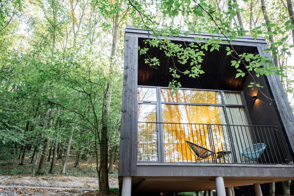 a tree house with a balcony in the woods at Buhta Vikingiv in Vodniki