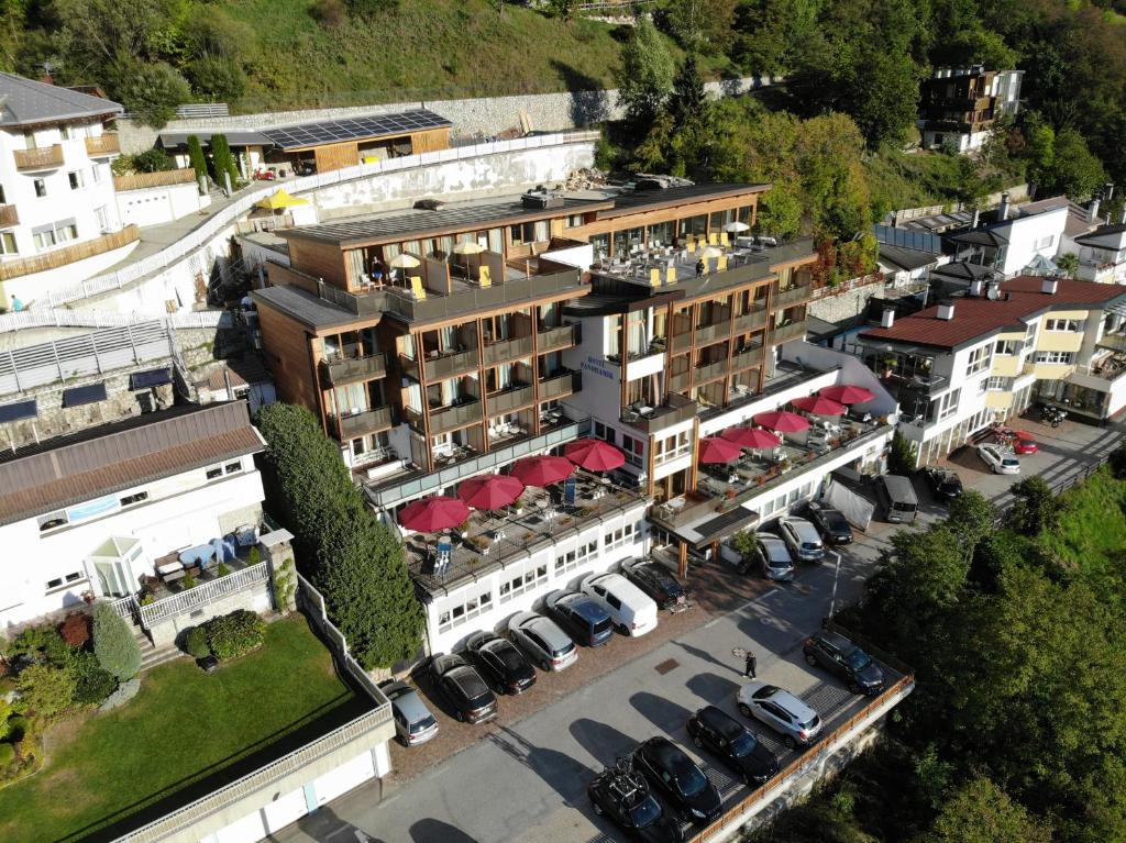 una vista in alto di un edificio con auto parcheggiate in un parcheggio di Hotel Panoramik a Mühlbach