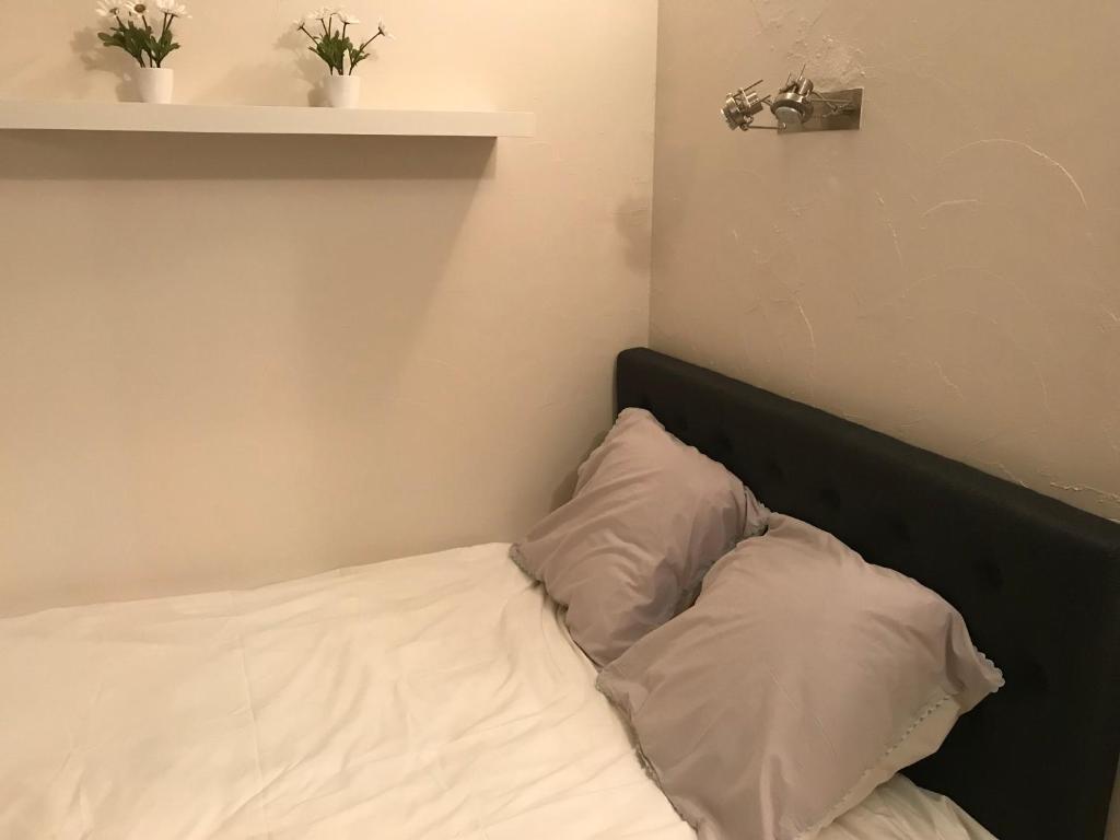 a bed with two white pillows in a room at Studio 2 pers en vieille ville parking gratuit - by La Source d&#39;OrFée in Boulogne-sur-Mer