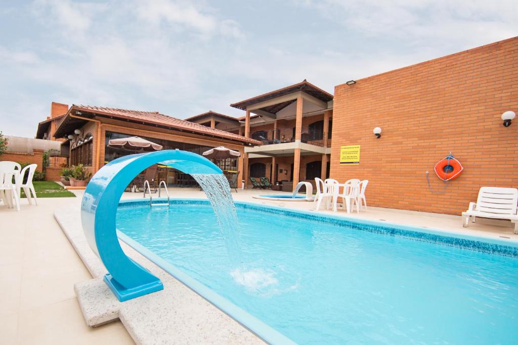uma piscina com um escorrega de água em frente a uma casa em Elite Hotel em Florianópolis