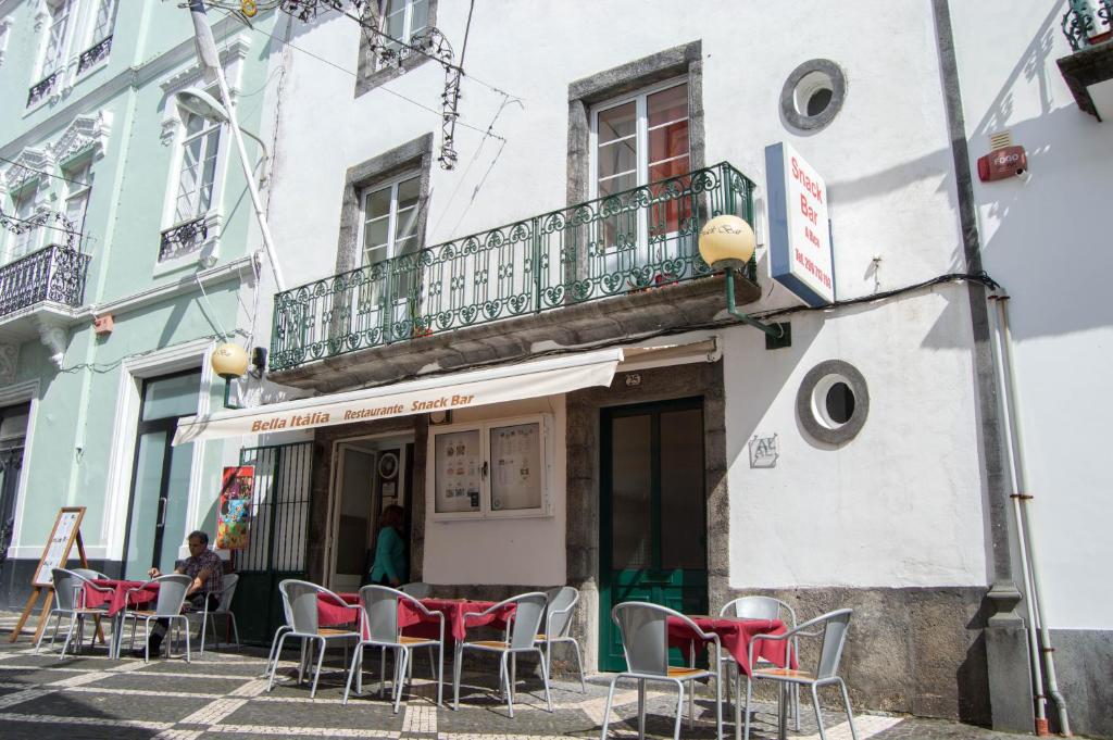 a group of chairs sitting outside of a building at Guest house Bella Italia in Ponta Delgada
