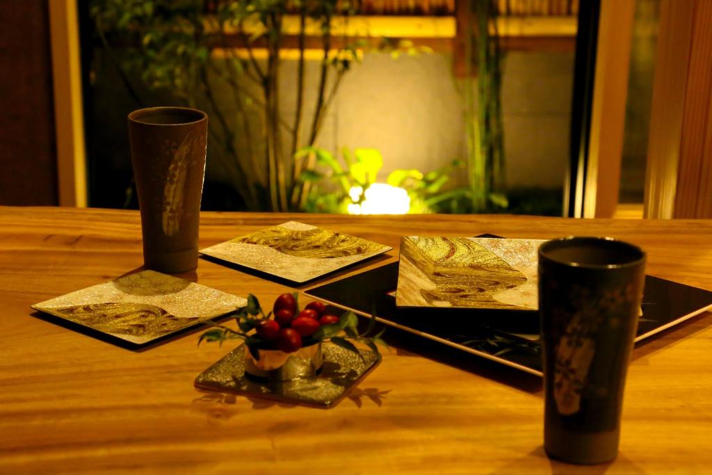 een houten tafel met twee kopjes en een fruitschaal bij Hosta Toji Sakura in Kyoto