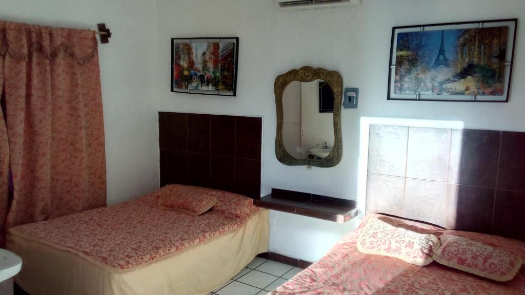 - une petite chambre avec 2 lits et un miroir dans l'établissement hotel quinta sierra, à San Blas