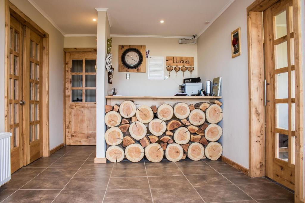 a pile of logs in a room with a counter at Hostal El Puestero in Puerto Natales