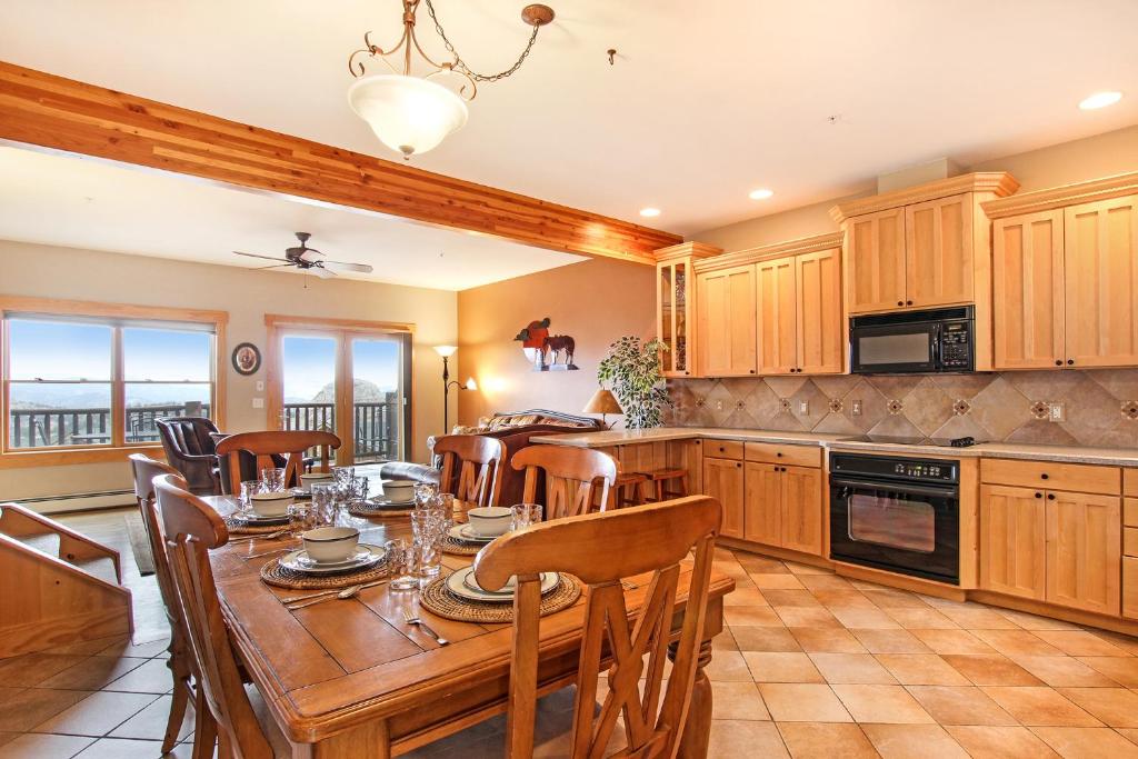 Mount Chapin S4 Condo في استيس بارك: مطبخ مع طاولة خشبية مع كراسي وغرفة طعام