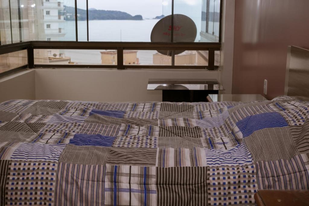 a bed in a room with a window at Meia Praia Apto 3Q in Itapema