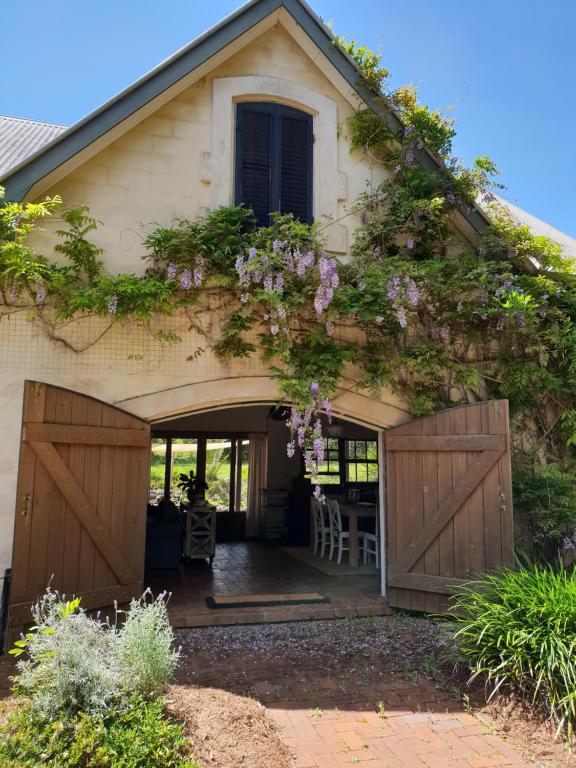 a house with a bunch of purple flowers on it at The Barn in Bangalow