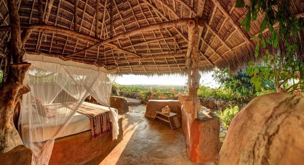 um quarto com uma cama num telhado de palha em Utopia Rote Lodge em Nembrala