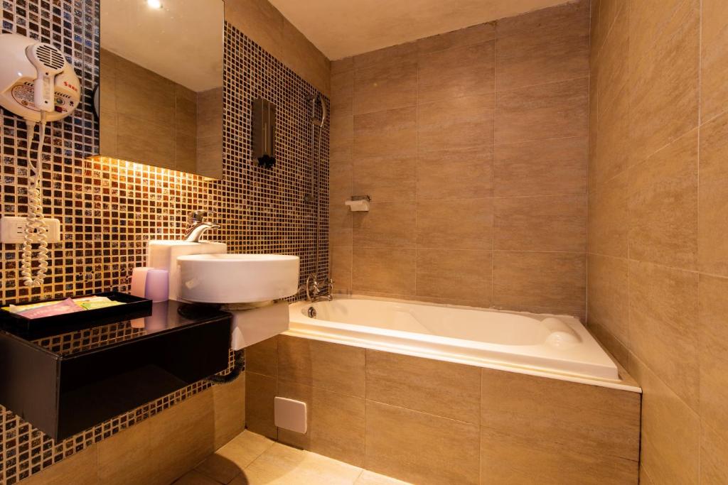 a bathroom with a bath tub and a sink at The Riverside Hotel Fashion in Kaohsiung