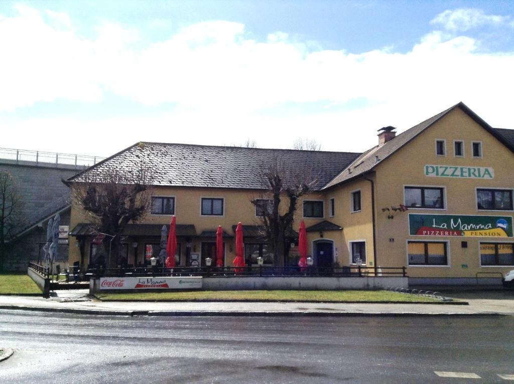 a building with flags in front of a street at Pension La Mamma in Aschach an der Donau