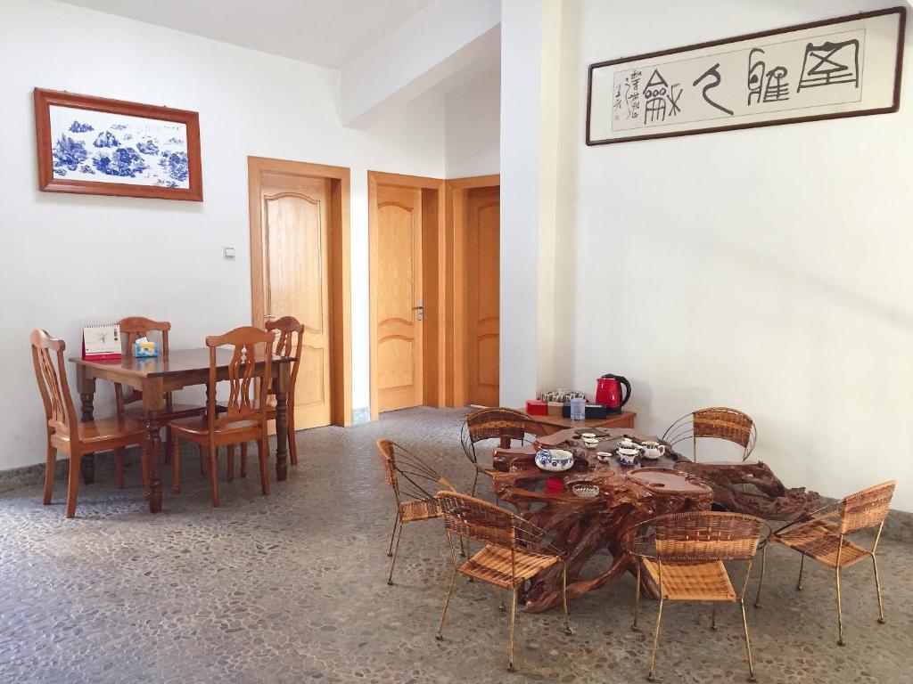 jadalnia z drewnianym stołem i krzesłami w obiekcie Taining Happy Stone Duplex Apartment w mieście Taining