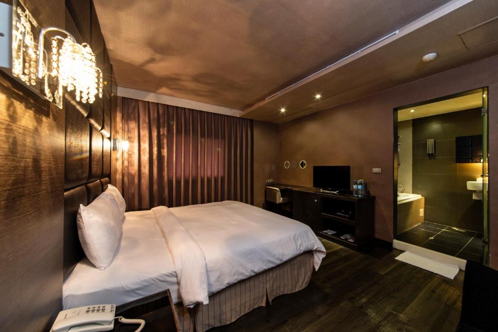 a hotel room with a bed and a bathroom at The Riverside Hotel Fashion in Kaohsiung