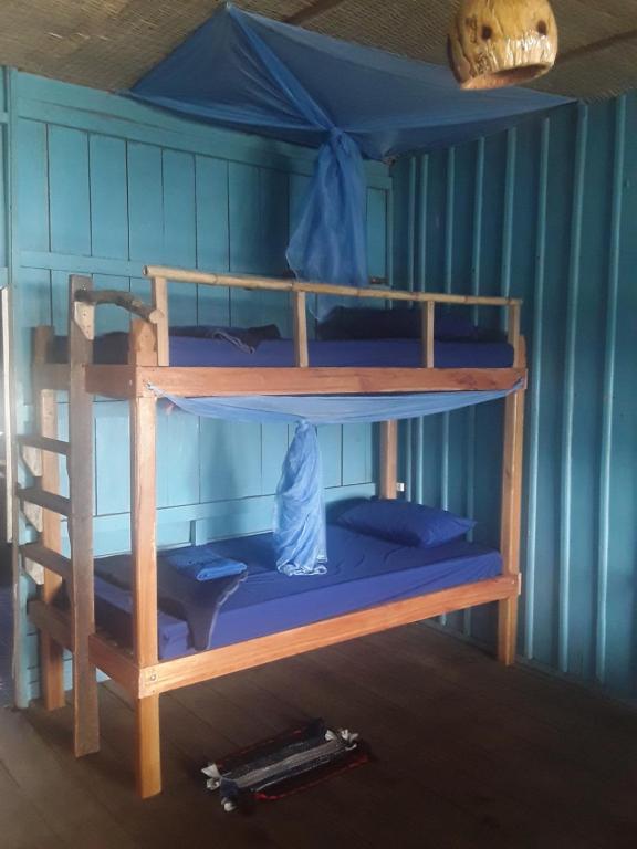 2 stapelbedden in een kamer met blauwe muren bij Firefly Guesthouse in Koh Rong Island