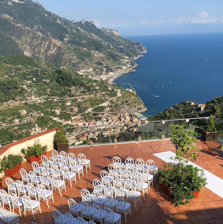 a row of white chairs sitting on top of a mountain at Hotel Bonadies in Ravello
