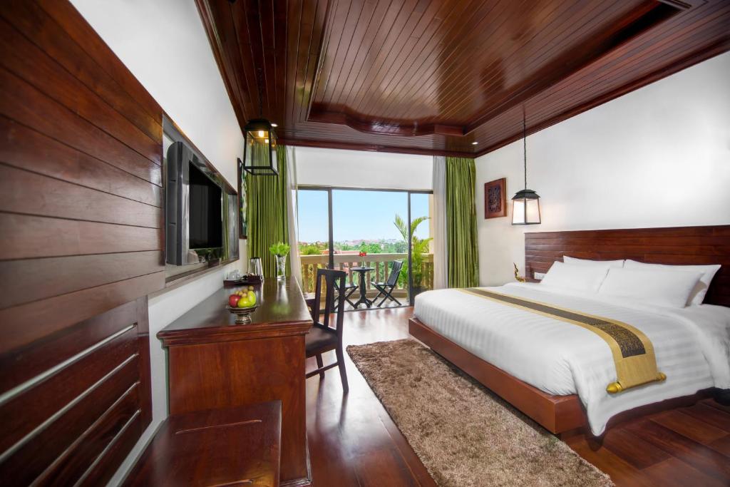 a bedroom with a bed and a large window at Borei Angkor Resort & Spa in Siem Reap