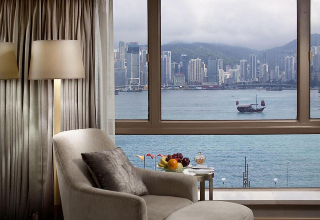 un soggiorno con finestra affacciata sull'acqua di The Royal Garden a Hong Kong