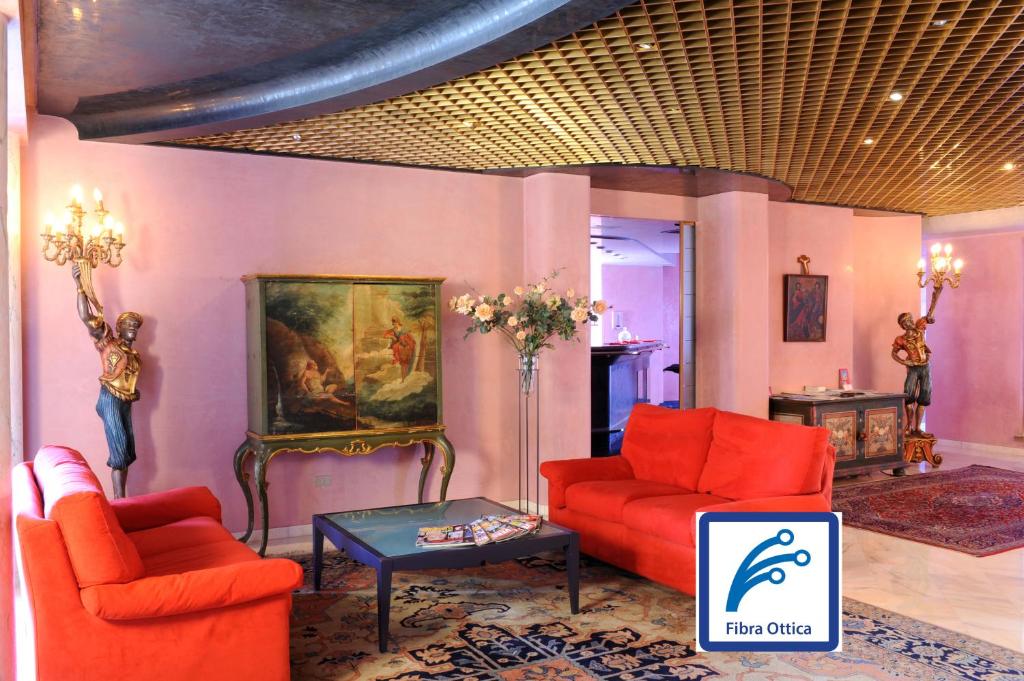 - un salon avec deux chaises rouges et une table dans l'établissement Hotel Ariane, à Thiene