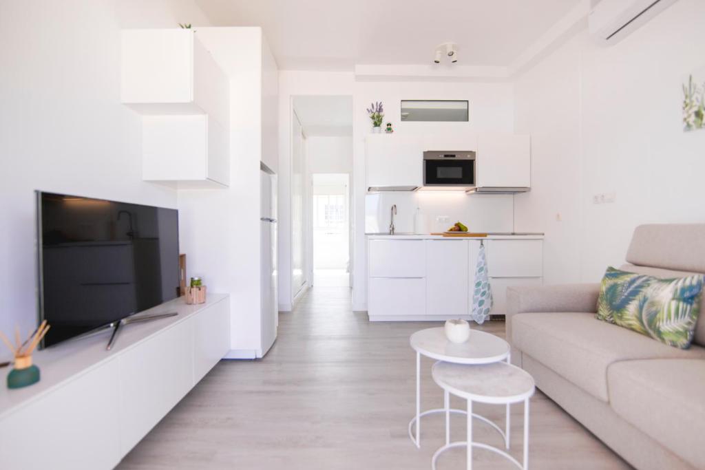 サンアグスティンにあるDeluxe Apartment. 50 meters Beachの白いリビングルーム(ソファ、テーブル付)
