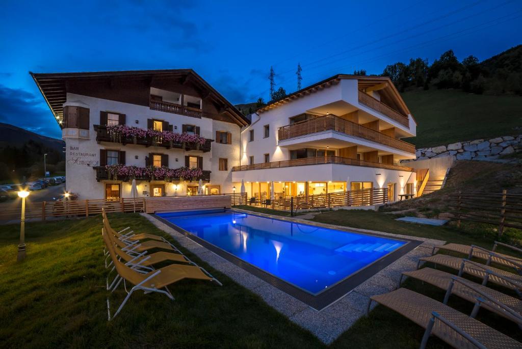 a villa with a swimming pool in front of a building at Hotel Restaurant Schaurhof in Vipiteno