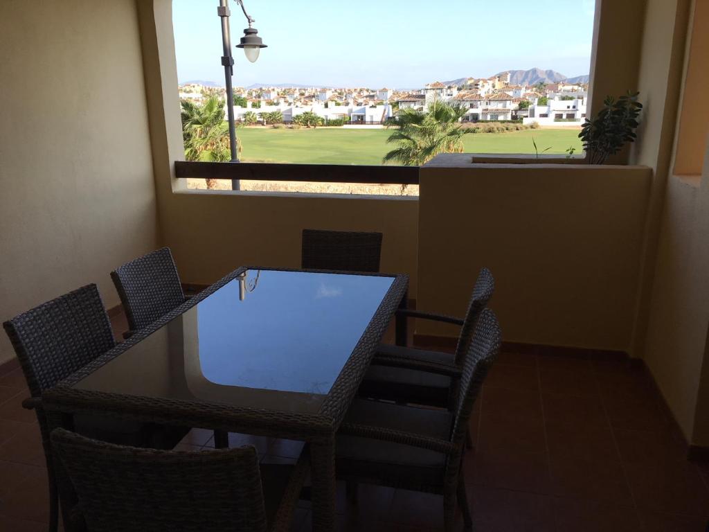 Las CasicasにあるThe Boulevard Mar Menor Golfのゴルフコースの景色を望むテーブルと椅子