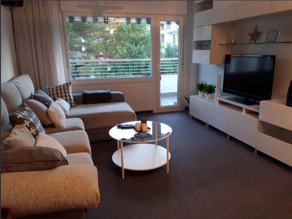 sala de estar con sofá, TV y mesa en Piso en Bakio a 100 metros de la playa, en Bakio