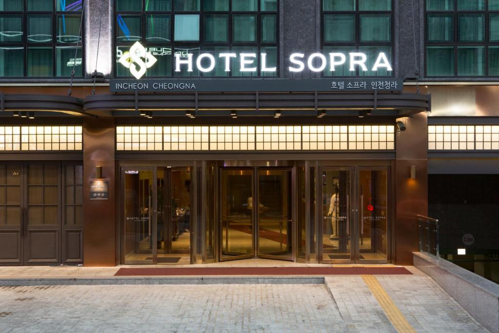 Hotel Sopra Incheon Cheongna في انشيون: مدخل الفندق بأبواب دوار على مبنى