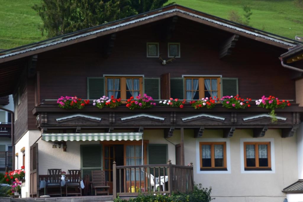 ein Haus mit Blumen auf dem Balkon in der Unterkunft Haus Schwaighofer in Neukirchen am Großvenediger