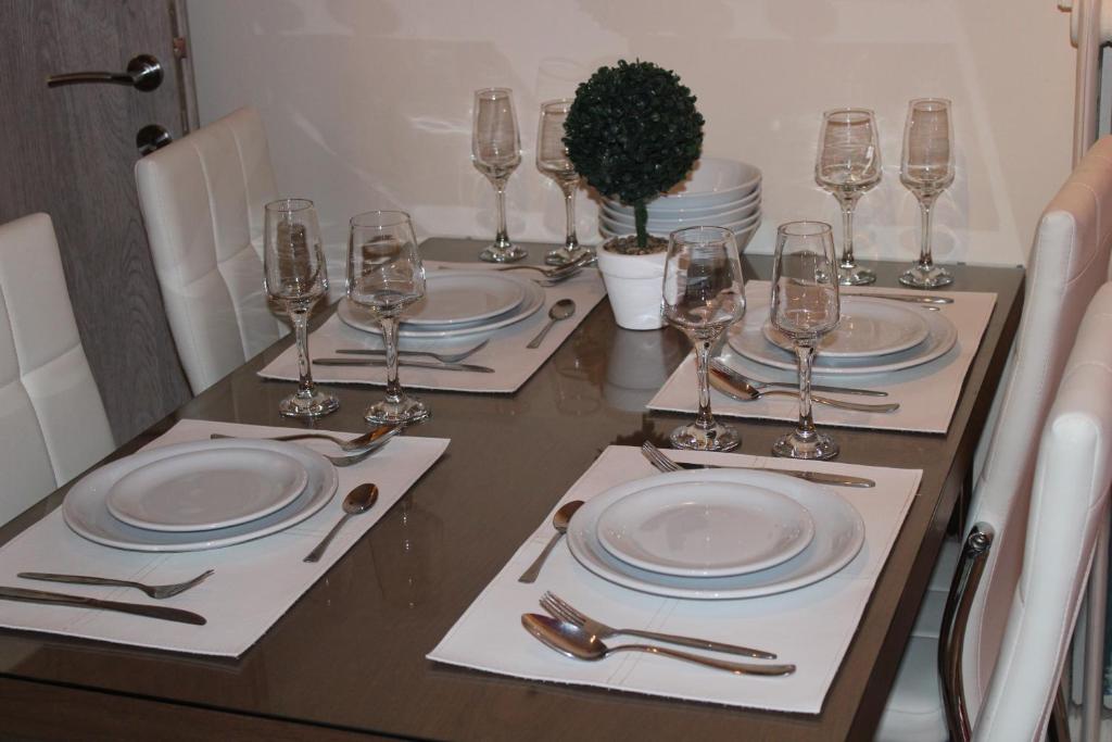 a table with plates and wine glasses on it at Mesochoriou Apartment in Thessaloniki